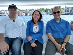 Andy Rebele, CEO of Pure Watercraft, US Senator Maria Cantwell, and Tom Ranken, CEO of the CleanTech Alliance on the water in a boat powered by and Pure Watercraft electric motor.